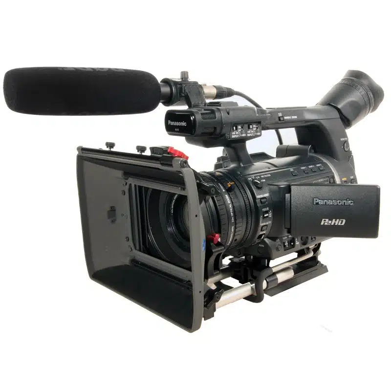 Panasonic AG-HPX250 professional video camera for rent, shown with a mounted microphone, lens hood, adjustable viewfinder, and stabilized on a tripod base—perfect for high-definition filmmaking and video production.