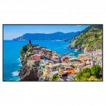 Colorful coastal village houses perched on a rocky cliff above the vibrant blue sea, with lush green hills and mountains in the background under a clear sky. Ideal wall art or poster for home decor featuring scenic seaside landscape.