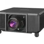 Black Panasonic projector with a large central lens and side ventilation grilles, placed on a flat surface. High-definition multimedia projector ideal for home theater or office presentations.