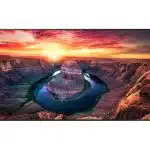 Horseshoe Bend wall art print showing a dramatic U-shaped curve in the Colorado River, surrounded by towering red rock cliffs at sunset, with a vibrant, fiery sky and bright sun overhead. Perfect home decor for nature and landscape lovers.