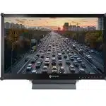 Computer monitor displaying a high-resolution image of heavy traffic on a multi-lane highway at sunset, with numerous cars lined up and city buildings visible in the background. Ideal for home office or professional workspace setups.