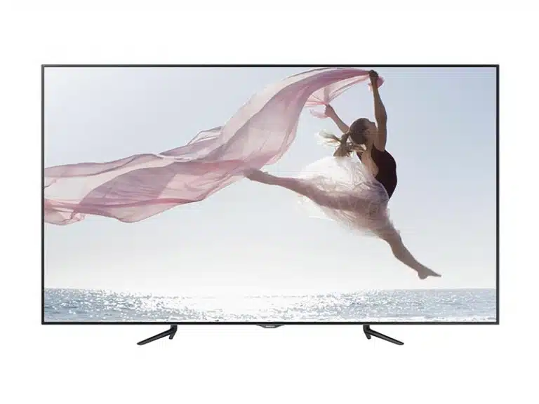 95 Zoll LED LCD Display Samsung ME95C mieten - das Produktbild zeigt das große, flache Display mit schlankem schwarzen Rahmen. Auf dem Bildschirm ist eine Ballerina abgebildet, die am Meer elegant mit wehendem rosa Stoff federt, während im Hintergrund die Sonne scheint. Ideal für gestochen scharfe Präsentationen und auffällige Werbeauftritte.