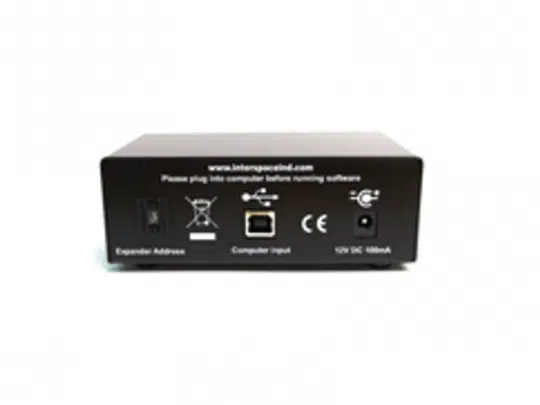 Rückansicht des schwarzen Soft CountDown Geräts von Interspace Industries mit Anschlüssen für Expander Adresse, Computer Input und 12V DC Stromversorgung; Website www.interspaceind.com oben sichtbar. Das Gerät ist zum Kaufen oder Mieten erhältlich.
