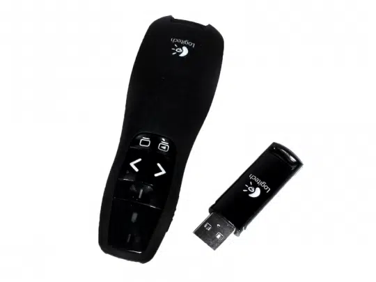 Der Logitech R400 Presenter und der passende USB-Empfänger liegen nebeneinander auf weißem Hintergrund. Der schwarze Presenter besitzt Navigationsstasten und das silberne Logitech-Logo. Ideal zum Steuern von Präsentationen - jetzt günstig kaufen oder mieten.