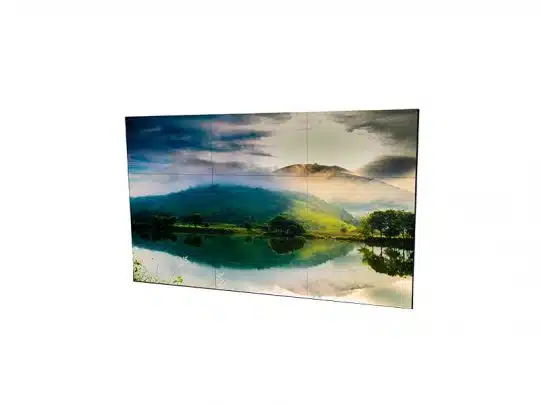 Steglose Videowand 3x3 aus neun nahtlos aneinandergereihten 55 Zoll Displays, auf denen eine brillante Landschaft mit grünen Hügeln, Nebelschwaden und spiegelndem See unter dramatischem Himmel angezeigt wird - ideale Mietlösung für visuelle Präsentationen.