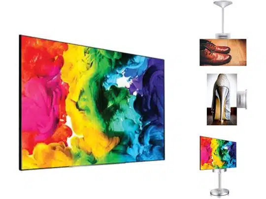 Zu sehen ist ein LG 55EH5C 55 Zoll OLED doppelseitiges Display als Komplettset zur Miete, links im Bild mit buntem Abstract-Motiv. Rechts daneben stehen drei Monitore auf Ständern, die jeweils Schuhbilder zeigen: braune Schuhe, einen weißen High Heel und bunte Sneaker. Ideal für Messe oder Event-Präsentationen.