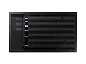 Rückansicht des schwarzen Samsung QB13R-T 13 Zoll FHD Displays mit geriffelter Oberfläche, HDMI-, USB- und LAN-Anschlüssen sowie seitlicher Fachabdeckung. Perfekt zum Mieten oder Kaufen für Digital-Signage-Lösungen.