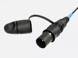 Schwarzer, runder Stromstecker mit Schutzkappe am Band vor hellem Hintergrund - idealer elektrischer Verbinder zum Kaufen oder Mieten.