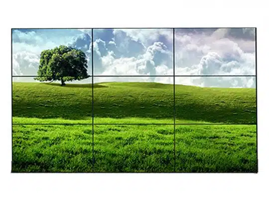 3 x 3 Steglos Videowand Paket 165 Zoll - Samsung UD55E-B (Gebrauchtware), bestehend aus neun rahmenlosen Bildschirmen, zeigt als großes Gesamtbild ein grünes Feld mit Baum unter bewölktem Himmel; perfekte Lösung zum Kaufen oder Mieten für beeindruckende Präsentationen und Werbeanzeigen.