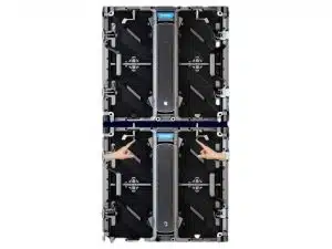 Zwei schwarze LED-Wand-Module vom Typ Unilumin URMIII 2.6 MK2 Pro sind übereinander auf weißem Hintergrund gestapelt; beide Module haben ein zentrales blaues Label und einen vertikalen Griff, Hände deuten auf das untere Modul hin - ideal zum Mieten von LED-Displays.