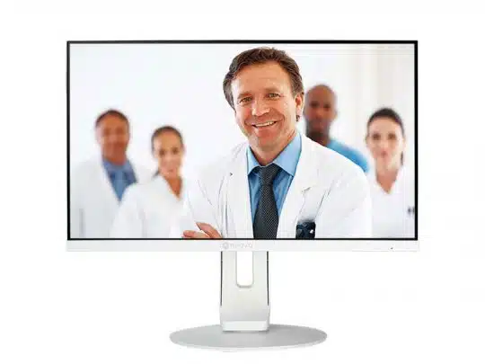 Ein Computer-Monitor zeigt das Bild eines lächelnden männlichen Arztes im weißen Kittel, im Hintergrund stehen drei weitere Mediziner. Ideal für Praxen, die Monitore kaufen oder mieten möchten.