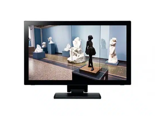 Auf dem Bildschirm eines Computers ist das Kunstwerk "Virtual Museum Gallery" zu sehen, das Sie mieten oder kaufen können. Die digitale Galerie zeigt mehrere weiße Marmorskulpturen und eine zentrale schwarze Ballerina-Statue in einer Glasvitrine, umgeben von blauen Wänden.