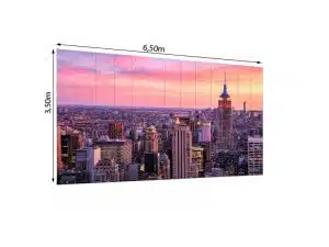 LED Wand 6.50m x 3.50m - 2.6mm URMIII 2.6 MK2 Pro zeigt auf dem Produktbild eine brillante Stadt-Skyline bei Sonnenuntergang, mit dem Empire State Building vor violett-pinken Wolken - ideale hochauflösende LED-Videowand zum Mieten für beeindruckende visuelle Erlebnisse.