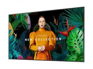 Samsung QB85C 85 Zoll Smart Signage Display zeigt Werbebild einer Frau in orangefarbenem Kleid mit Tasche vor tropischen Blättern. Der Bildschirm wirbt für die "Spring New Collection" und lädt dazu ein, die neuesten Styles zu mieten oder zu kaufen.