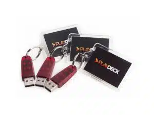 Drei rote PLAYDECK Lite Dongles mit silbernem Schlüsselring und einer schwarzen Karte mit PLAYDECK-Logo liegen nebeneinander auf weißem Hintergrund. Die PLAYDECK Lite Dongles dienen als Lizenzschlüssel für die professionelle Playout-Software, die flexibel gemietet oder gekauft werden kann.