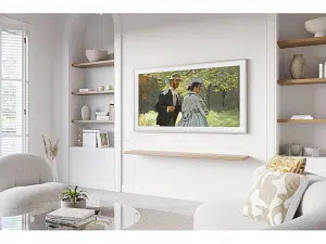 Samsung The Frame 43 Zoll 4K/UHD QLED-TV ist stilvoll an einer weißen Wand in einem modernen Wohnzimmer mit neutralen Farbtönen montiert, über einem schwebenden Regal und vor eingebauten Regalen sowie einem Glastisch - ideal zum Mieten für ein elegantes Wohnambiente.