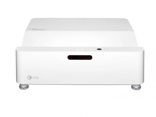 Optoma Projektor in Weiß, rechteckiges Design mit Bedientasten oben und vier kleinen Standfüßen; auf der Vorderseite sind das Optoma-Logo und ein "Designed for sustainability"-Label sichtbar.
