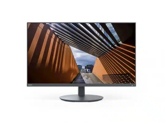 Computer-Monitor zeigt ein Foto einer modernen Architektur mit orangefarbenen Wänden und einem schattenspendenden Lamellendach; im Hintergrund sind weitere Gebäude unter einem bewölkten Himmel zu sehen. Ideal als hochauflösender PC-Bildschirm für Architektur- und Design-Präsentationen.