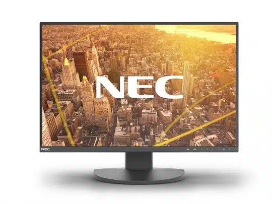 NEC Computer-Monitor auf rundem Standfuß vor weißem Hintergrund. Auf dem Bildschirm ist eine Luftaufnahme einer Stadt bei Sonnenuntergang und zentriert das weiße NEC-Logo zu sehen.