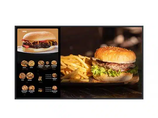 Digitales Menü zeigt einen Burger mit Bacon und Käse sowie weitere Menüoptionen; daneben auf einem Holzbrett einen Cheeseburger mit Salat, dazu Pommes Frites - leckeres Fast Food-Angebot auf moderner Menütafel.