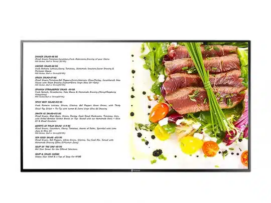 Digitales Anzeigedisplay mit Restaurant-Menü auf der linken Seite und einem farbenfrohen Teller mit Salat, gebratenem Thunfisch, grünen Blättern, Cherrytomaten und Garnitur auf der rechten Seite. Ideal für digitale Menüanzeigen in Restaurants.