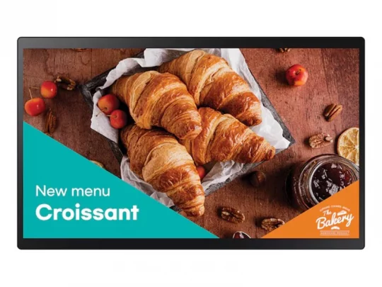 Croissants auf einem Backblech, umgeben von roten Früchten, Pekannüssen und Marmelade. Text: „Neue Speisekarte: Croissant – The Bakery“.