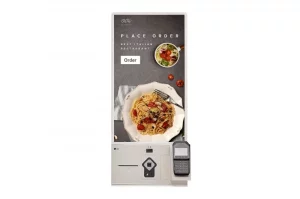 Selbstbestellungskiosk: Das Touchscreen-Terminal zeigt ein Gericht mit Pasta und Salat sowie eine gut sichtbare „Bestellen“-Schaltfläche zur Bestellung von Speisen. Unten rechts ist ein Kartenlesegerät für kontaktloses Bezahlen angebracht. Ideal für barrierefreies Bestellen von Speisen in Restaurants oder Kantinen.