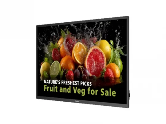 Produktbild eines digitalen Displays mit frischem Obst und Gemüse wie Äpfeln, Tomaten und Salat, von Wasser bespritzt. Auf dem Bildschirm steht in weiß-grüner Schrift: „NATURE’S FRESHEST PICKS – Fruit and Veg for Sale“. Ideal für Menschen mit Sehbehinderung, die eine Beschreibung aktueller Angebote für frische Lebensmittel suchen.