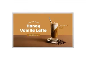 Ein Honig-Vanille-Latte, gekühlt serviert in einem hohen Glas mit Strohhalm, steht auf einem braunen Untergrund neben Kaffeebohnen; auf beigem Hintergrund sind der Produktname, die Größe (16 oz) und der Preis ($5,50) zu sehen.