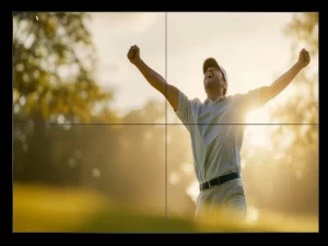 Golfer-Kappe: Ein Golfer mit Kappe reckt jubelnd beide Arme in die Luft auf einem sonnigen Golfplatz; im Hintergrund sind verschwommene Bäume und helles Sonnenlicht zu sehen. Ideal für alle Golfbegeisterten – die perfekte Kombination aus Funktionalität und sportlichem Stil.