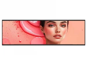 Das Produktbild zeigt das geschminkte Gesicht einer Frau auf einem digitalen Display vor einem rosa-pfirsichfarbenen Hintergrund mit flüssigen Tropfen und sanften Strukturen. Ideal für die Präsentation von Kosmetikprodukten wie Foundation oder Gesichtsserum.