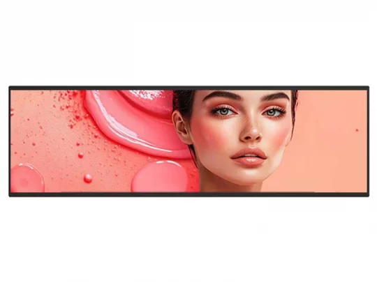 Das Produktbild zeigt das geschminkte Gesicht einer Frau auf einem digitalen Display vor einem rosa-pfirsichfarbenen Hintergrund mit flüssigen Tropfen und sanften Strukturen. Ideal für die Präsentation von Kosmetikprodukten wie Foundation oder Gesichtsserum.