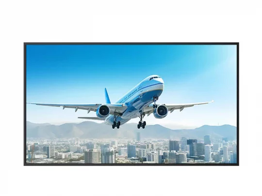 Ein Passagierflugzeug in blau-weißer Lackierung (Modell: Boeing 737) hebt über einer Stadt mit Hochhäusern ab; im Hintergrund sind Berge und ein klarer Himmel zu sehen.