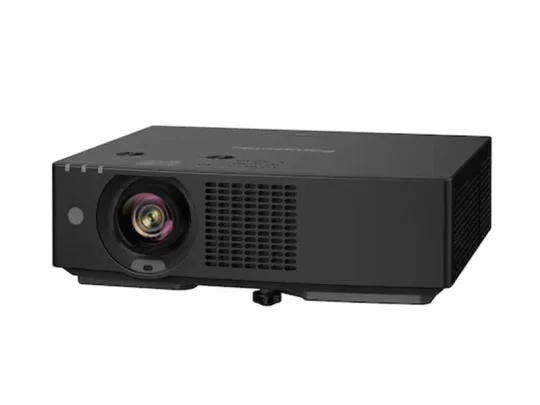 BenQ W1700 – schwarzer Beamer mit großem Objektiv auf der linken Seite und Lüftungsgittern an der Vorderseite, auf einer weißen Fläche stehend und leicht nach rechts ausgerichtet.