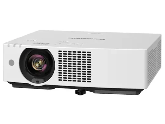Weißer Beamer, rechteckig, mit einer großen Linse vorne links, Lüftungsgittern und Bedientasten auf der Oberseite; steht auf einer ebenen Fläche. Ideal für Präsentationen oder Heimkino.
